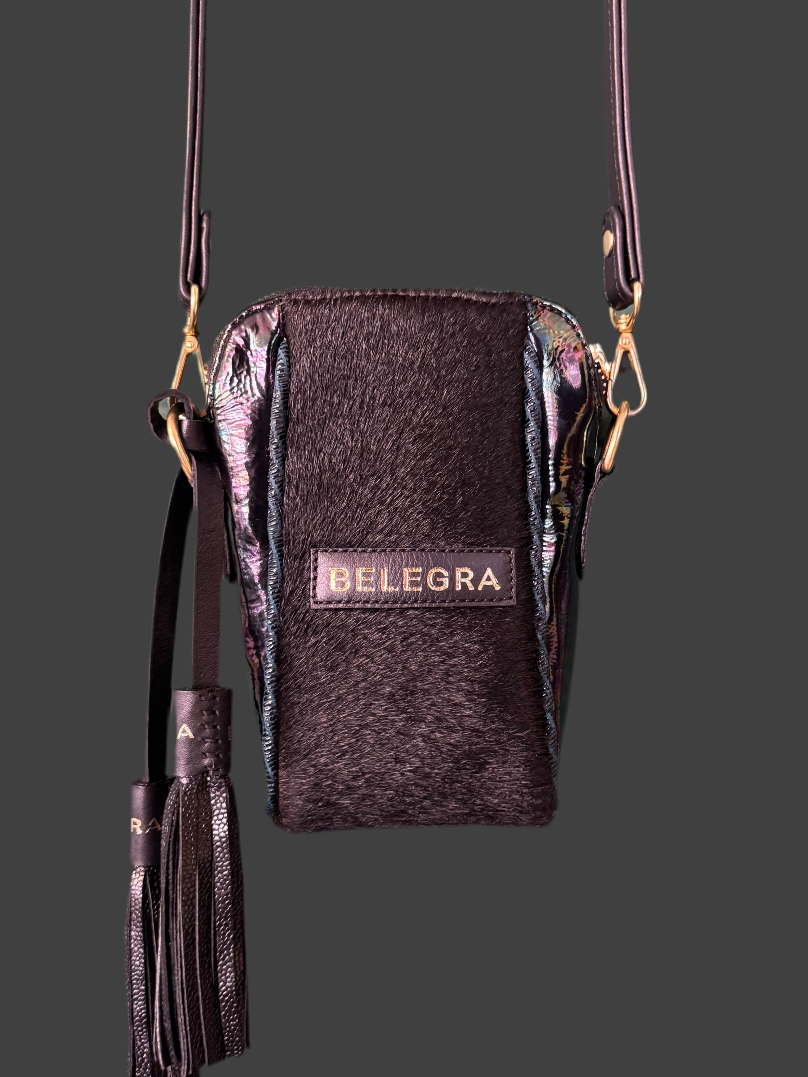 Black crossbody bag with tassel and 'BELEGRA' branding on a dark background
